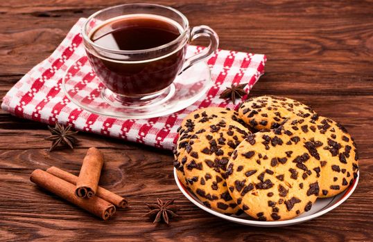 Cookies with chocolate, spices and a cup of coffee on a table close-up