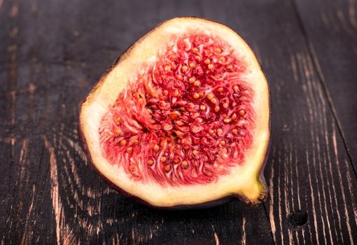 Cut in half fresh figs closeup on wooden background