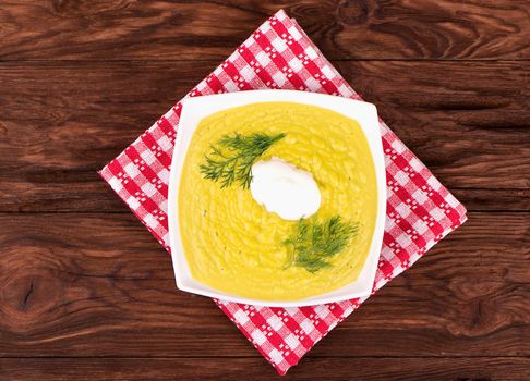 Vegetarian cream soup with vegetables on the plate on a towel on the table top view