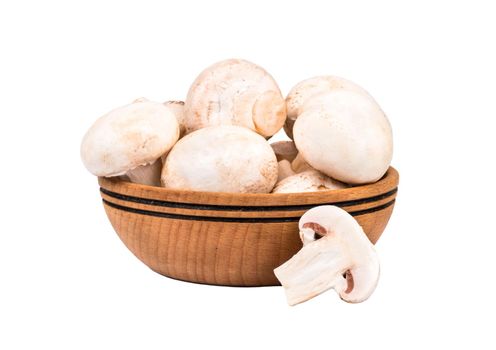 Wooden bowl filled with raw mushroom champignon on a white background