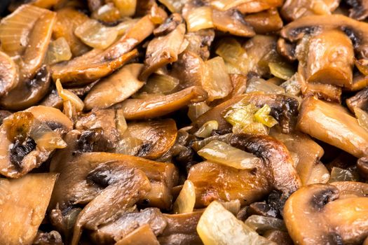 Fried champignon mushrooms with onion closeup