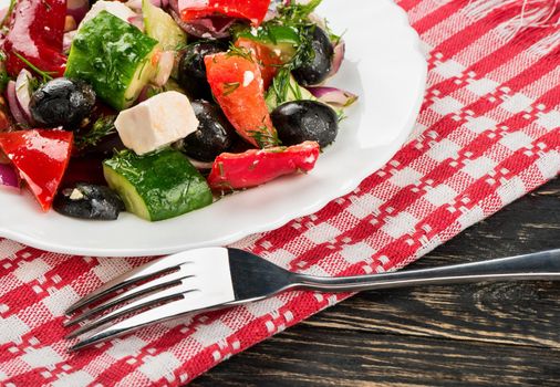 Part plates of fresh Greek salad on a towel