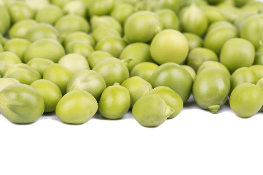 Scattered grains of green peas on a white background closeup
