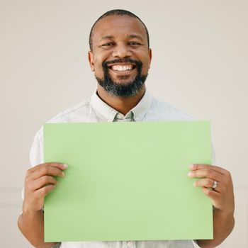 Studio shot of a mature man holding up a blank poster.