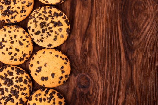 Homemade cookies with chocolate on an empty wooden background top view