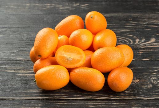 Pile of fresh fruit kumquat on the wooden background