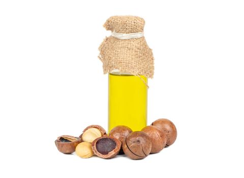 Macadamia nuts with oil in a bottle on a white background