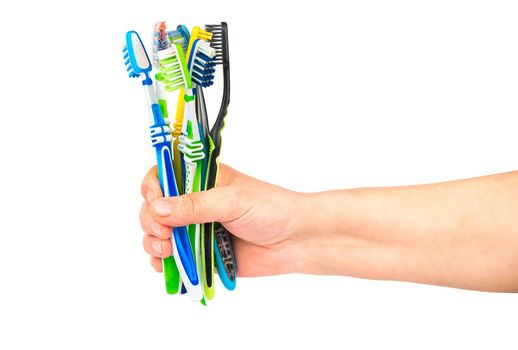 The woman holds in her hand a few toothbrushes on a white background