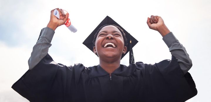 Low angle shot of a young woman cheering on graduation day.