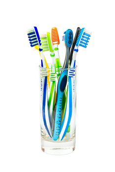 Many toothbrushes in a glass isolated on white background
