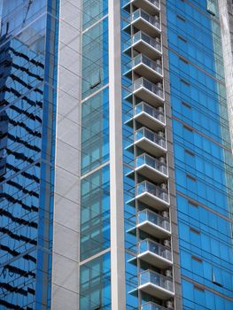 Modern Office-condo building detail with balconies in downtown Honolulu, Hawaii with another building reflected in it. Good for patterns and backrounds