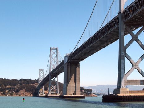 San Francisco side of Bay Bridge from ferry boat sailing underneath close to one of the support pillars.  Bridge enters into Yerba Buena island.