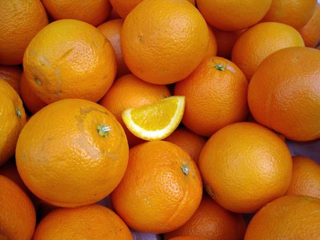 Organic Oranges with a small slice of orange in the middle on display at a farmers market in San Francisco