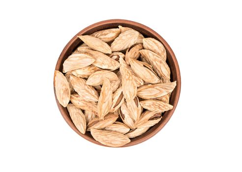 Wild uzbek almonds in bowl on white background, top view