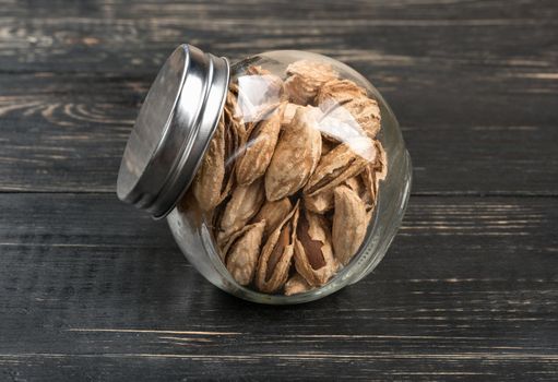 Wild uzbek almonds in a jar on wooden background