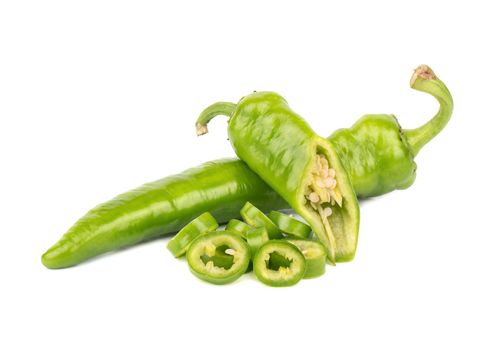 Green chili peppers and a half and slices on a white background