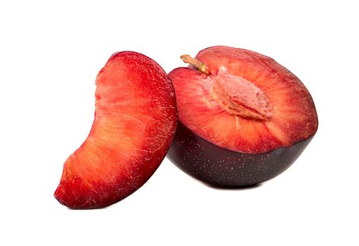 Half of a juicy red plum with slice on white background