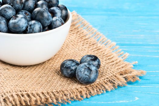 Bowl with blueberries and berries on the table, close-up