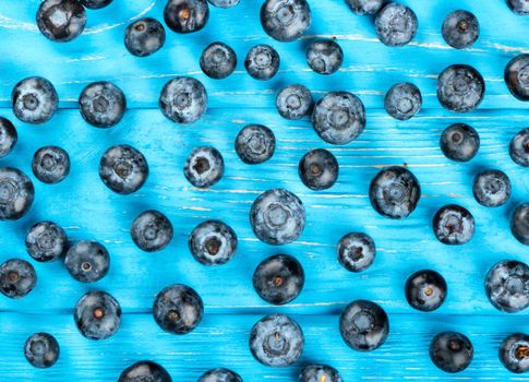 Background of fresh blueberries scattered on table, top view