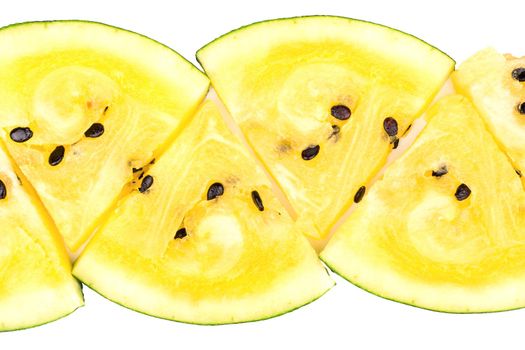 The triangular slices of yellow watermelon lined in a row on a white background, top view