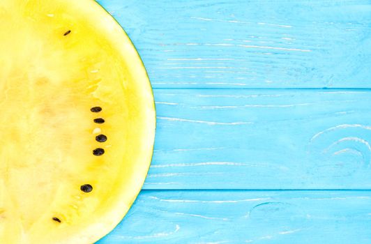 Half of yellow watermelon on a wooden background top view