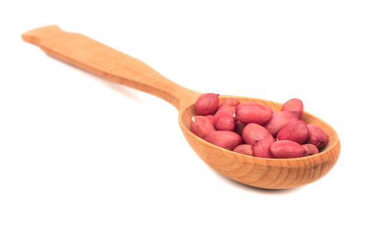 Kernel peanut in wooden spoon isolated on white background closeup