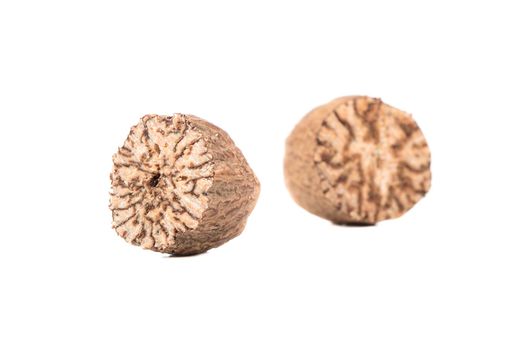 Two halves of dry nutmeg on white background