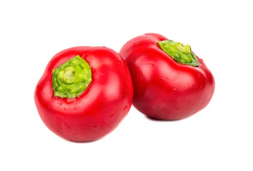 Two small red peppers on a white background