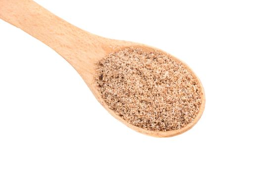 Grind nutmeg in wooden spoon on white background closeup