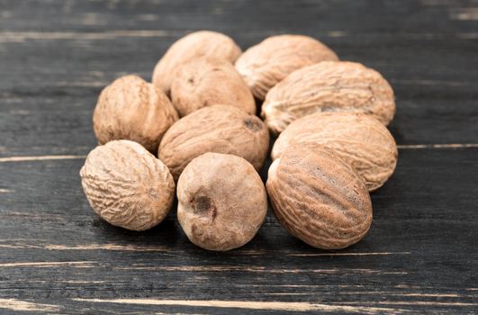 Few nutmegs in the dark table, close up