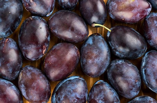 Background of ripe blue plums close-up view from above