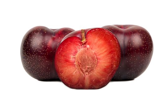 Big tasty red plum with half on white background