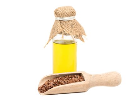 Flax oil in a bottle with a scoop of seed on white background