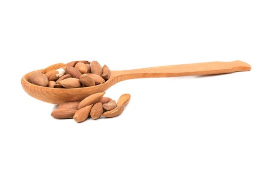 Uzbek almonds without shell in spoon on white background
