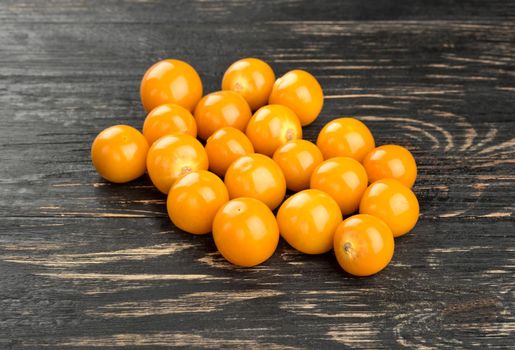 Small pile of ripe berries physalis on dark table