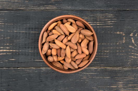 Bowl Uzbek of almonds on a dark table, top view