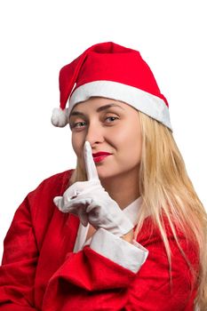 Beautiful girl in Santa costume holding finger near lips on white background