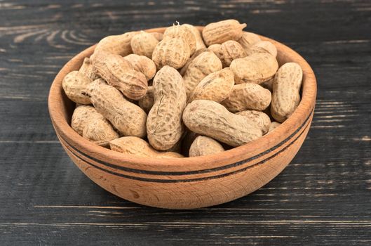 Dry peanuts in a shell and a bowl on a close-up table