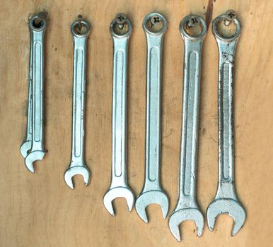 Different size old wrenches on the wall in the garage