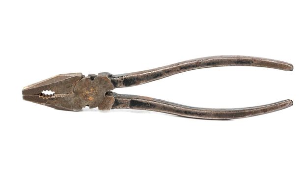 Old rusty pliers on white background closeup