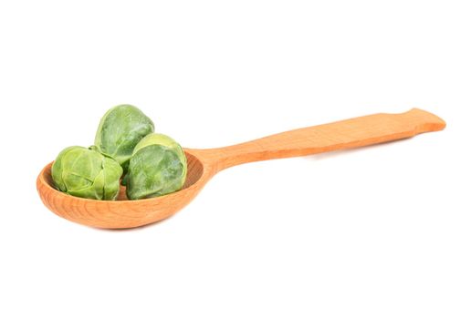 Fresh brussels sprouts in a wooden spoon on a white background