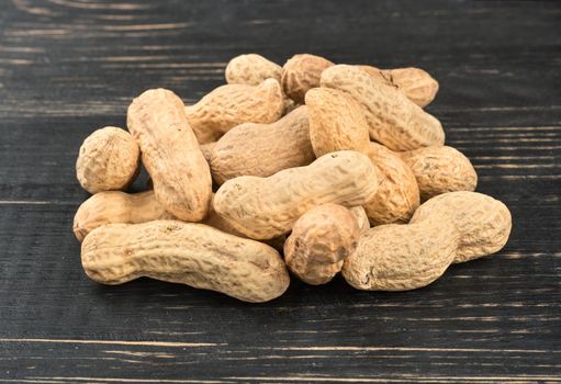 Bunch of peanuts in the shell on the table closeup