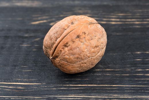 Walnut in shell on a dark table closeup