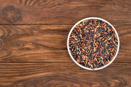 Black wild rice in white bowl on table, top view