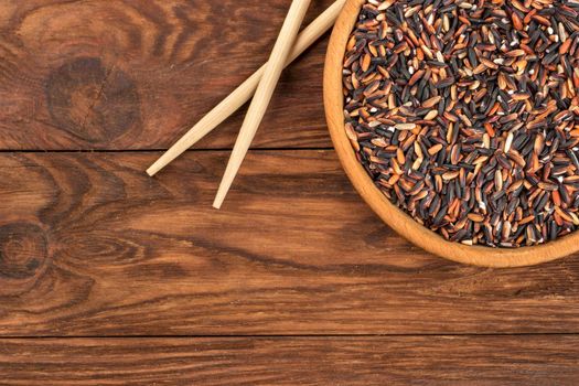 Wild rice in a bowl with chopsticks on the table top view