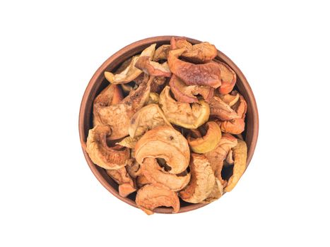 Slices of dry fruit apples in a bowl on white background, top view