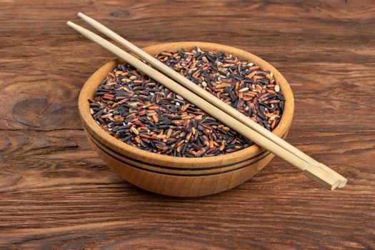 Wild rice in a bowl with chopsticks on the table