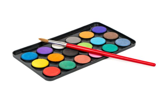 Plastic palette with paints and paintbrush on a white background