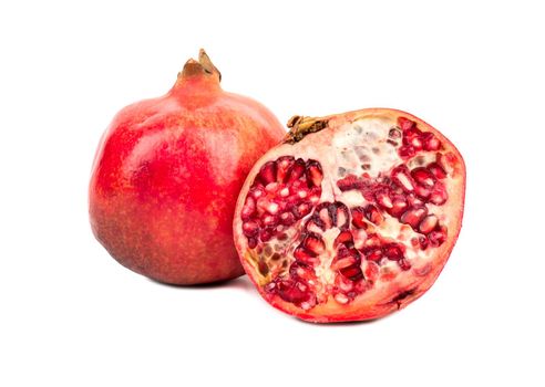 Ripe fruit with a juicy pomegranate half on a white background