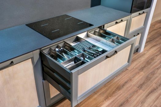 Open drawer with cutlery in the kitchen close-up